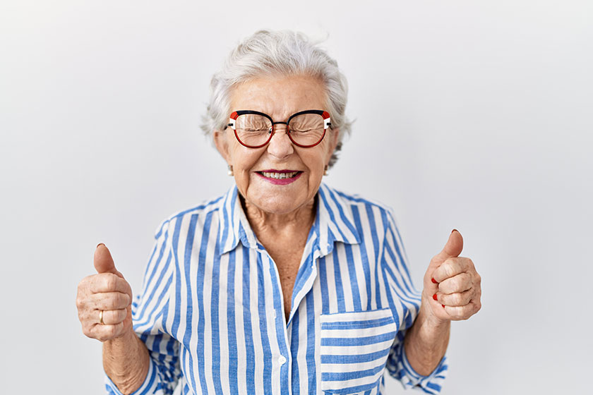 senior woman grey hair standing white background excited success arms