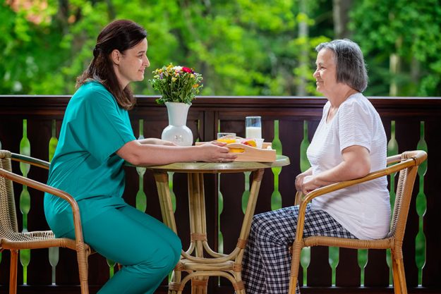 smiling young carer serving breakfast happy senior woman nursing home smiling young carer serving breakfast happy senior woman nursing home