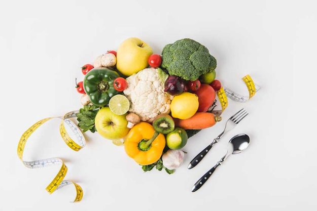 vegetables fruits laying white background fork spoon measuring tape