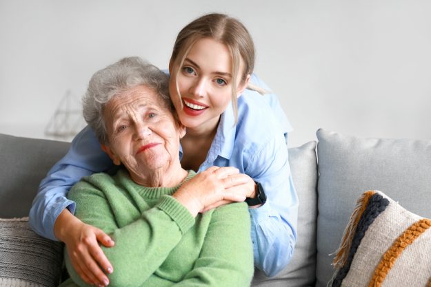 Young woman and her grandmother hugging at home Young woman and her grandmother hugging at home