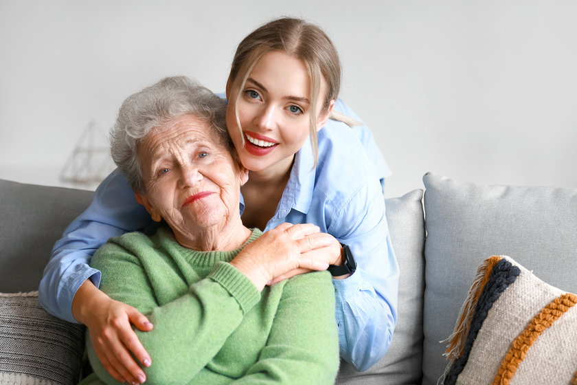 Young woman and her grandmother hugging at home Young woman and her grandmother hugging at home