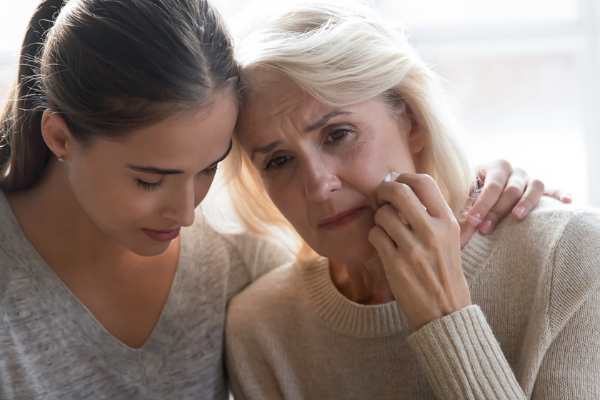 Close up young grown up worried daughter hugging frustrated mother. Close up young grown up worried daughter hugging frustrated mother.