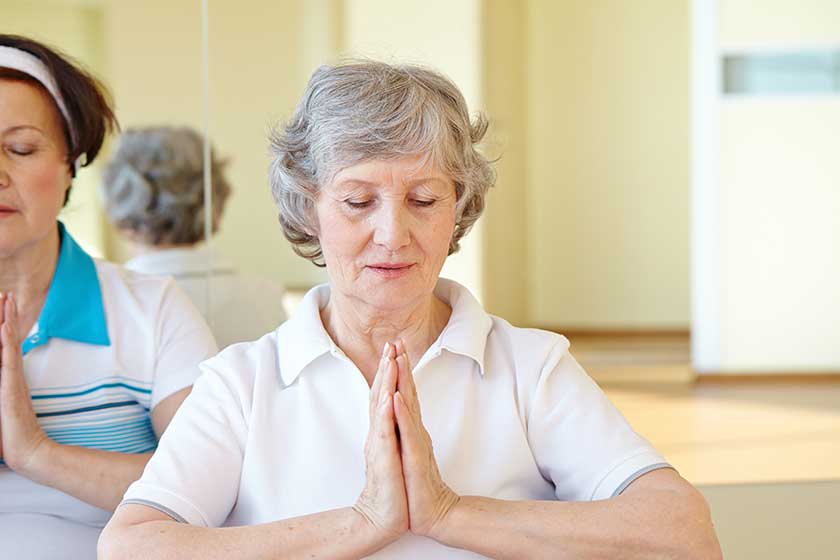 Aged women doing yoga exercise
