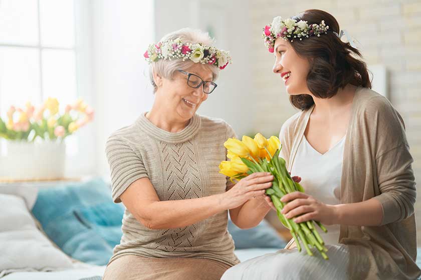 Beautiful young woman her mother flowers tulips hands home
