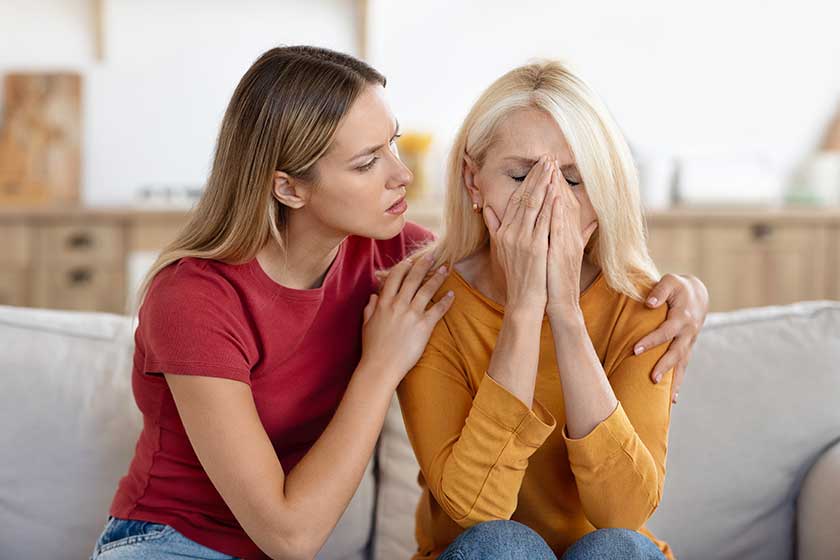 Caring grownup daughter comforting frustrated unhappy senior woman hugging sitting