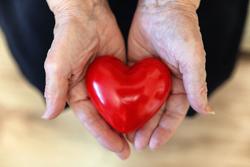 Gift box with red bow in grandmother hands