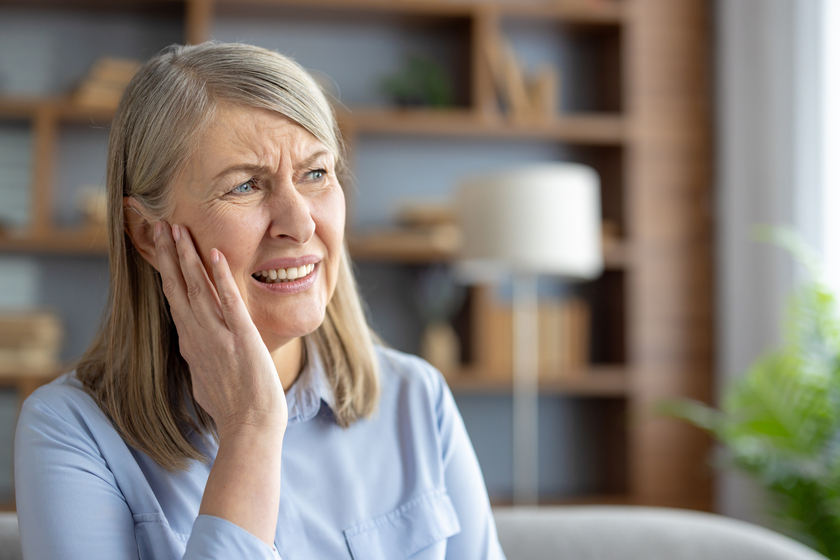 Senior woman feeling discomfort due to earache at home