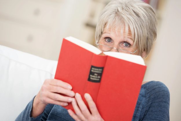 Elderly woman reading a book at home — Photo Elderly woman reading a book at home — Photo