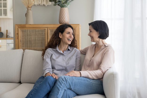 Happy excited mature mom and adult child woman talking and laughing at home — Photo