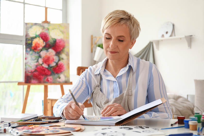 Mature female artist drawing sketch in workshop