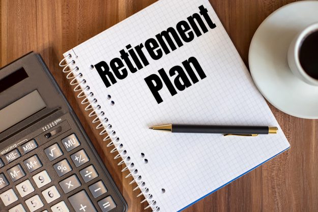 RETIREMENT PLAN written in a white notepad near a calculator and a cup of coffee on a dark wooden background — Photo