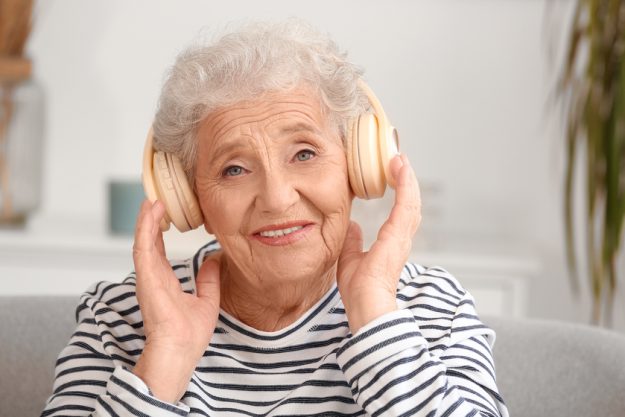 Senior woman in headphones at home, closeup