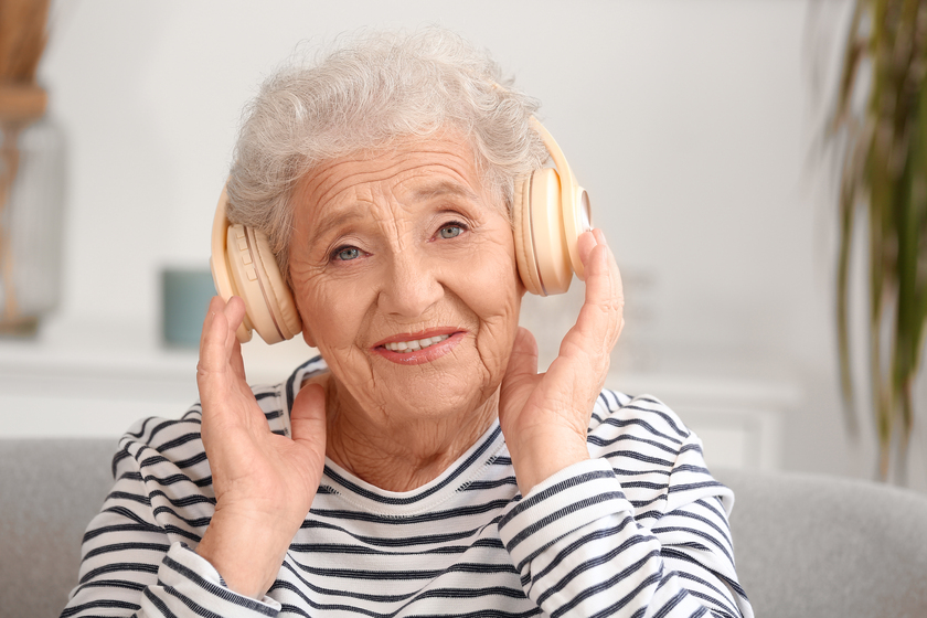 Senior woman in headphones at home, closeup