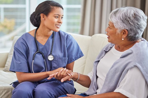 Hispanic senior woman cosy sofa her female nurse old age Hispanic senior woman cosy sofa her female nurse old age