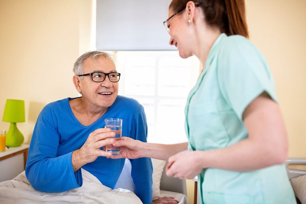 loving nurse handing glass water her nursing occupant elder peoples