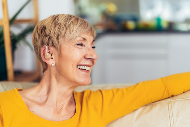 Mature woman hearing aid indoors smiling