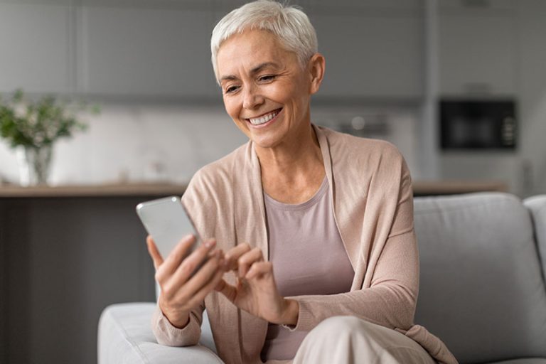 Relaxed senior woman enjoying using mobile apps cell phone texting Relaxed senior woman enjoying using mobile apps cell phone texting