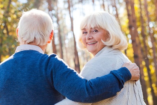 Senior woman walking by park with husband