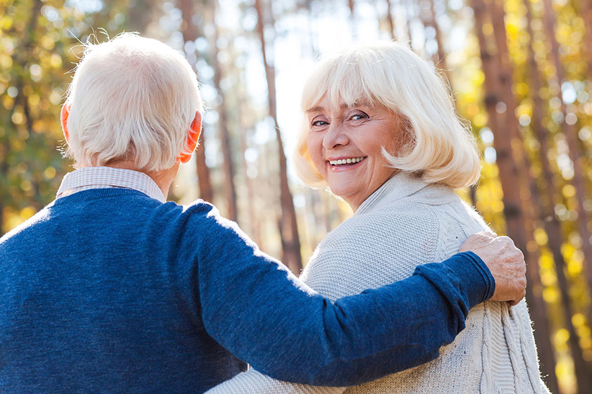 Senior woman walking by park with husband