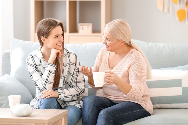 Mature woman and her adult daughter spending time together at home