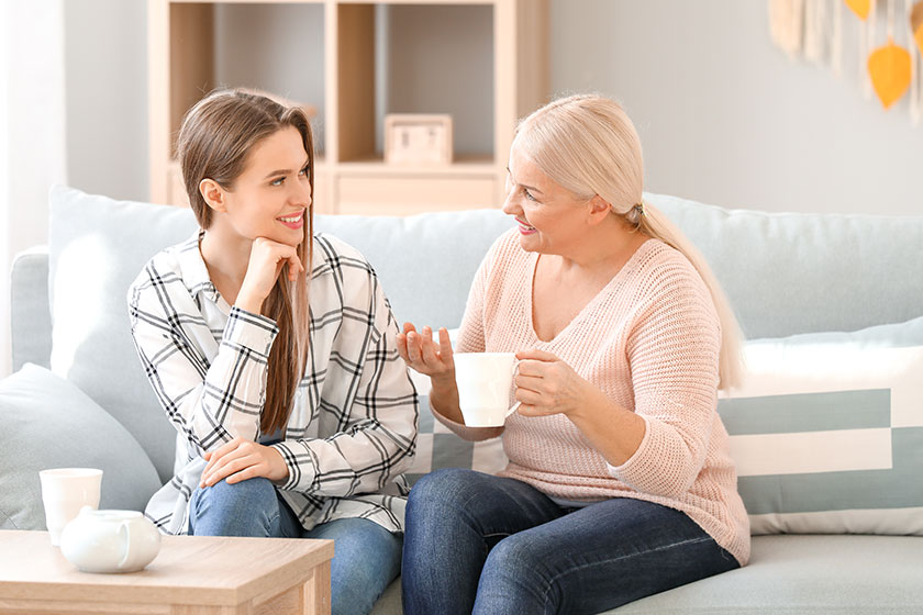 Mature woman and her adult daughter spending time together at home