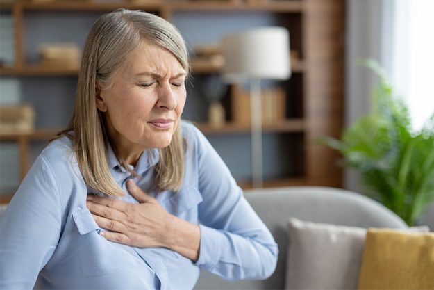 Mature woman experiencing discomfort holding her chest due pain she