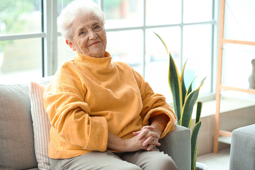 Senior woman sitting on sofa at home Senior woman sitting on sofa at home