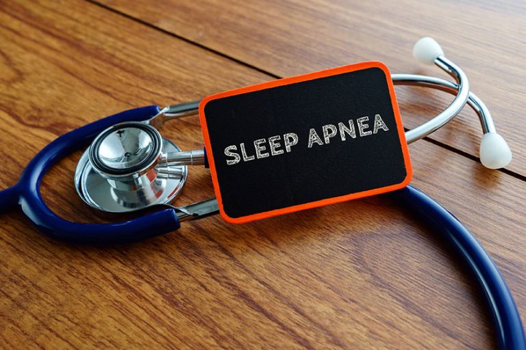 Word sleep apnea with stethoscope on wooden table Word sleep apnea with stethoscope on wooden table