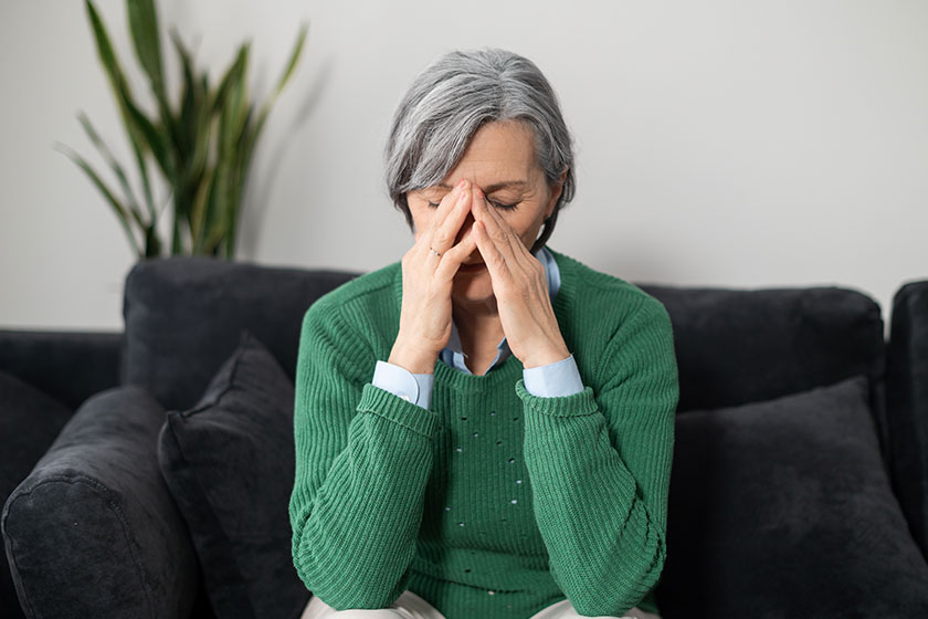 A portrait of a senior lady experiencing a migraine