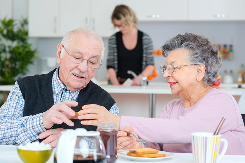 happy senior couple discussing while having breakfast