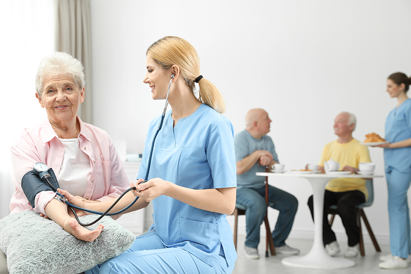 nurse measuring blood pressure of elderly woman