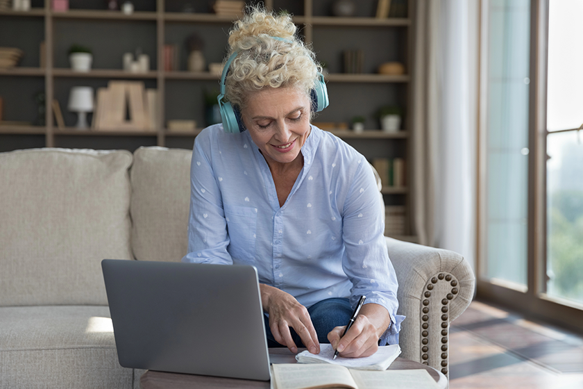 smiling attractive middle aged female headphones listen audio