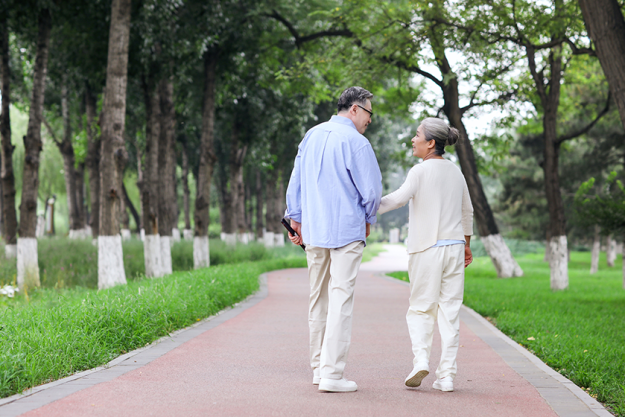 happy old couple walking in the park