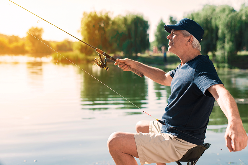 the old man is sitting on the river bank
