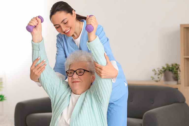 young caregiver senior woman training dumbbells