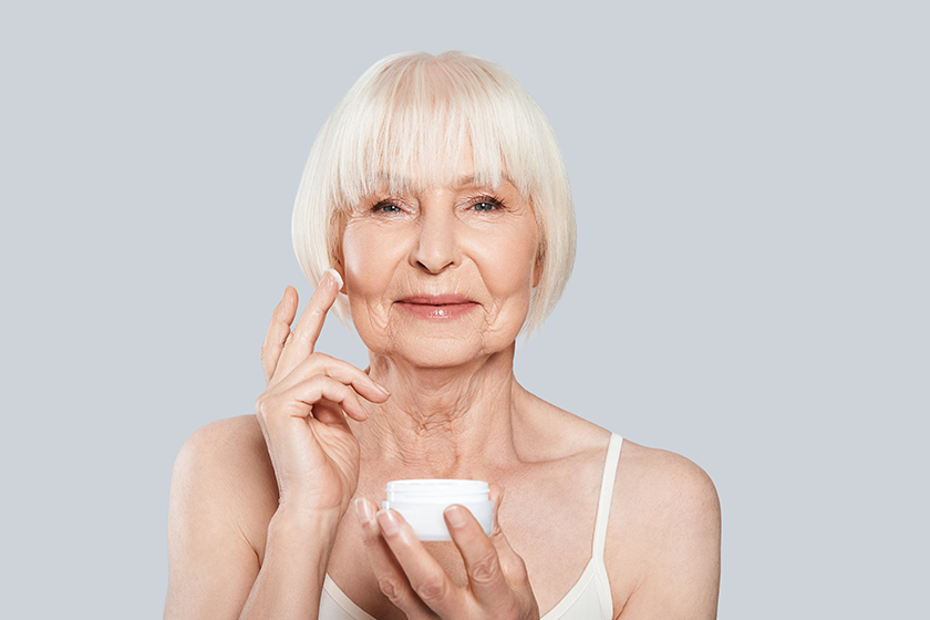 beautiful senior woman applying beauty cream