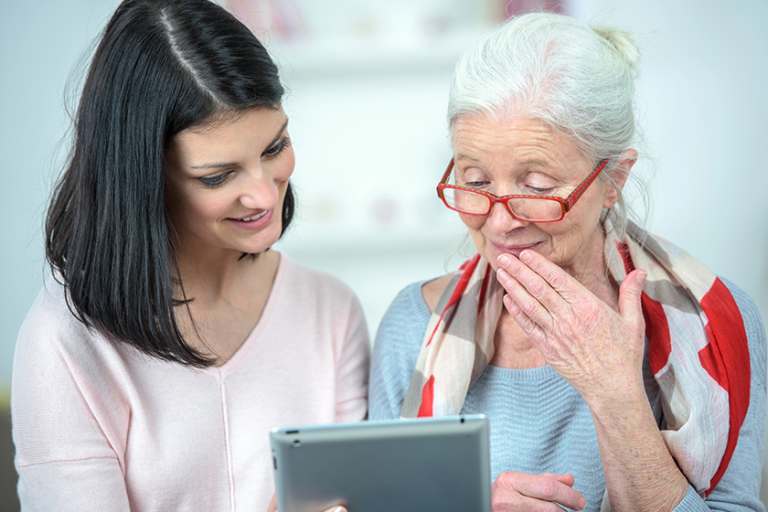 helping old woman use a tablet helping old woman use a tablet