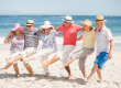 senior friends dancing on the beach