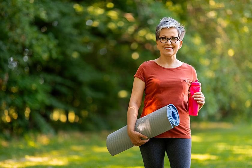 smiling senior woman holding water bottle smiling senior woman holding water bottle
