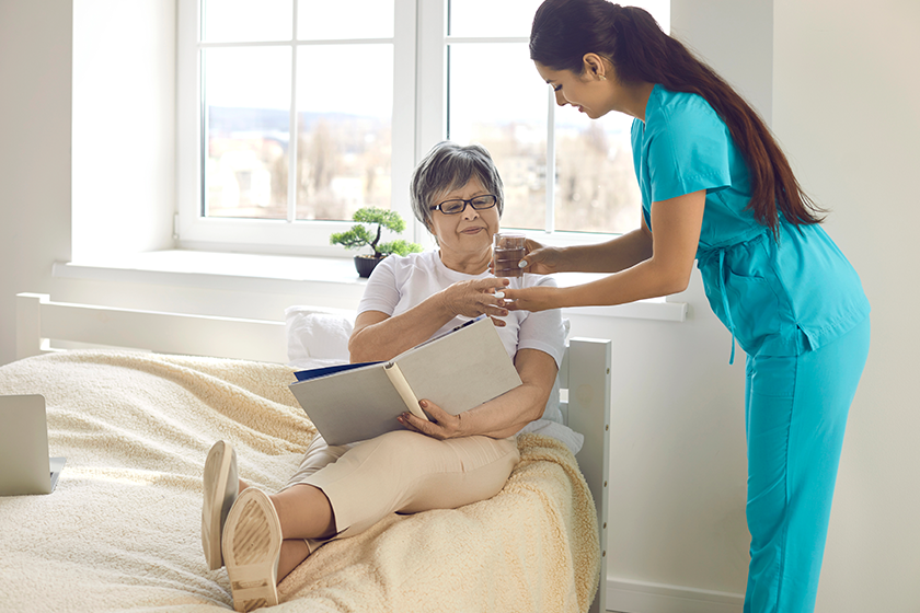 woman nurse giving prescribed pills and glass of water