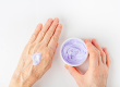 elderly woman creaming her hands