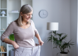 happy senior woman examines her weight loss