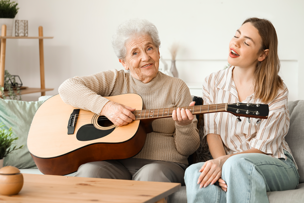 young woman her grandmother playing guitar young woman her grandmother playing guitar